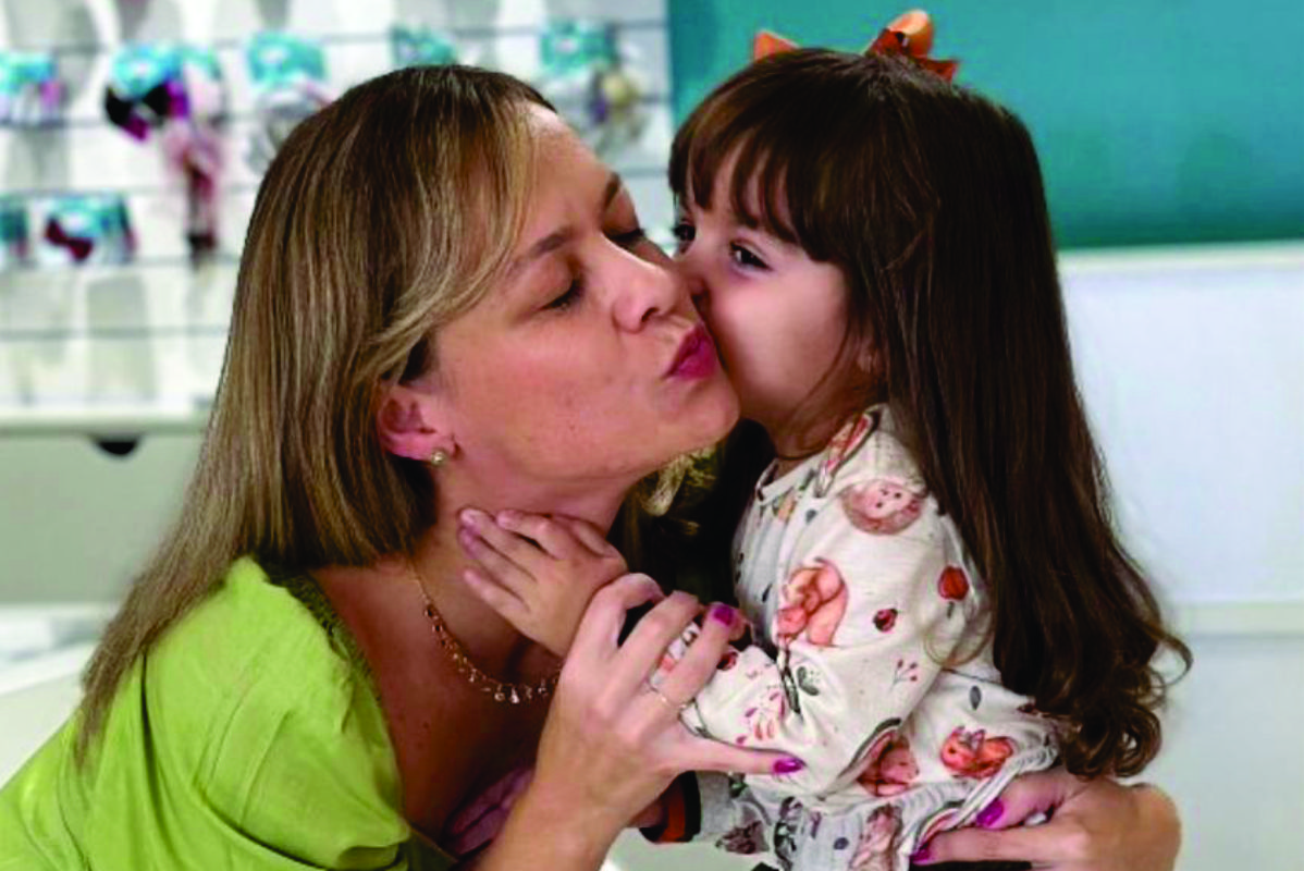 Mãe e filha sorrindo em ambiente lúdico